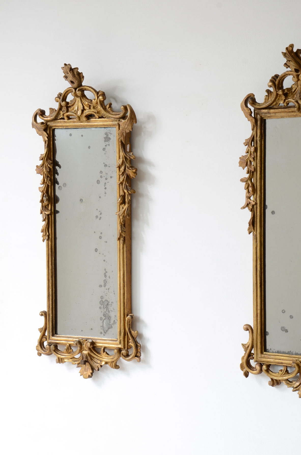 Pair of very refined and elegant carved and gilded wooden mirrors, 1730-1750