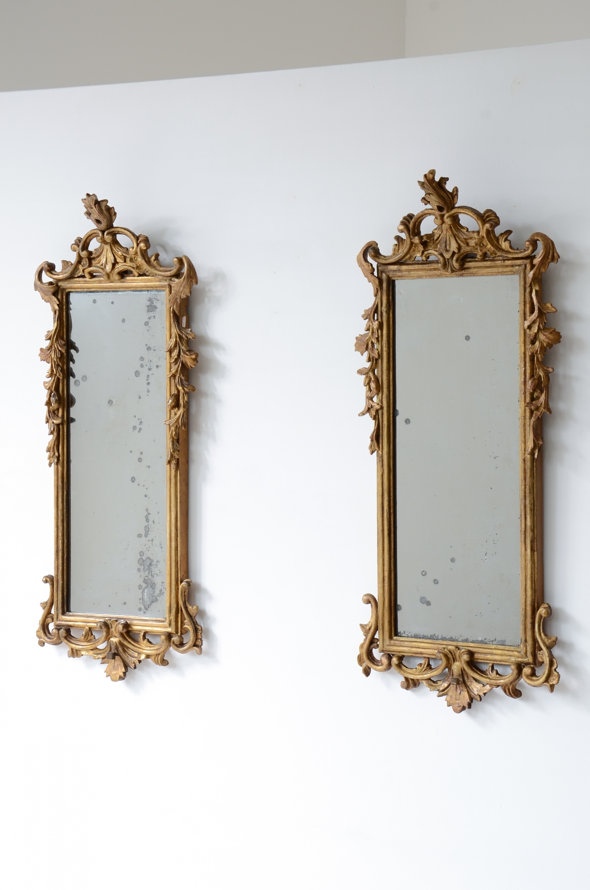 Pair of very refined and elegant carved and gilded wooden mirrors, 1730-1750