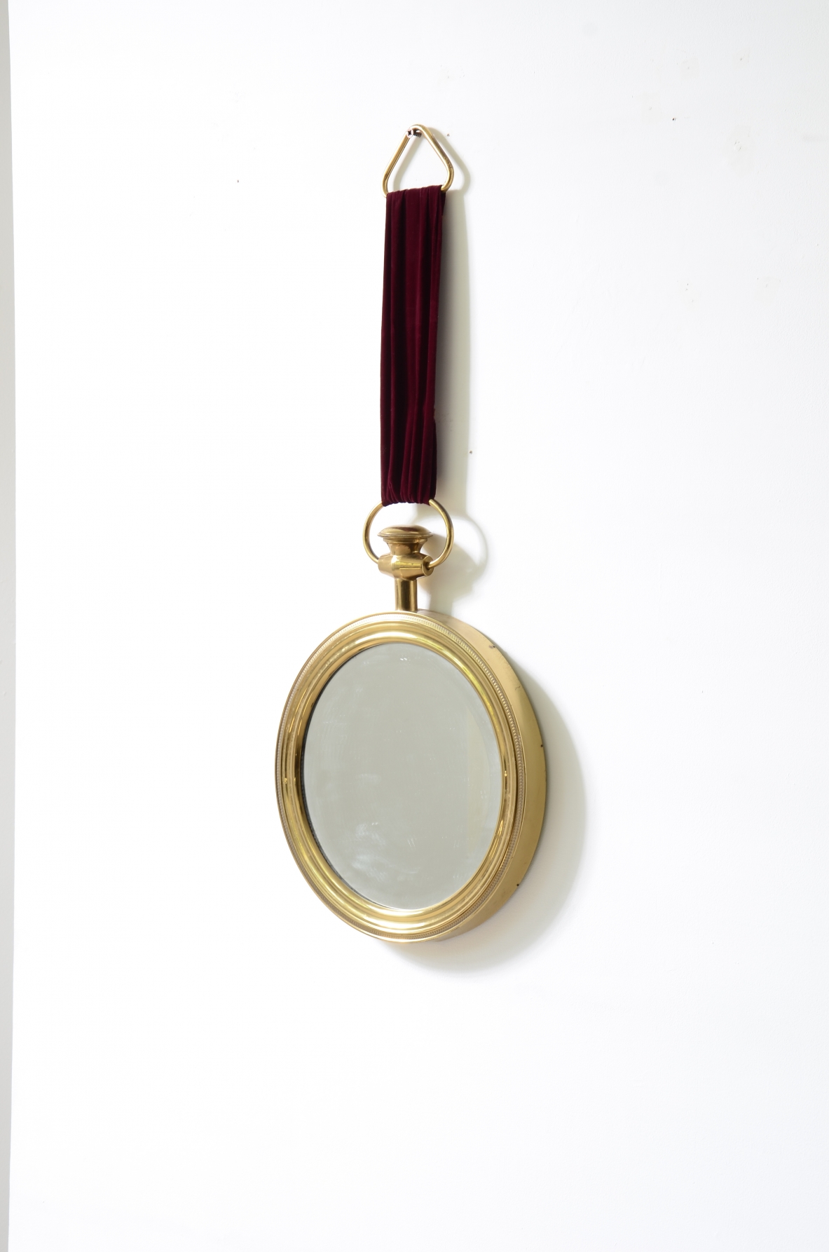Elegante specchio in ottone sagomato nello stile di Piero Fornasetti. Anni '50