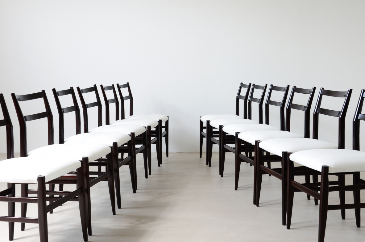 Set di 12 sedie modello leggera in legno tinto nero con rivestimento in tessuto.  Manifattura Cassina 1954.